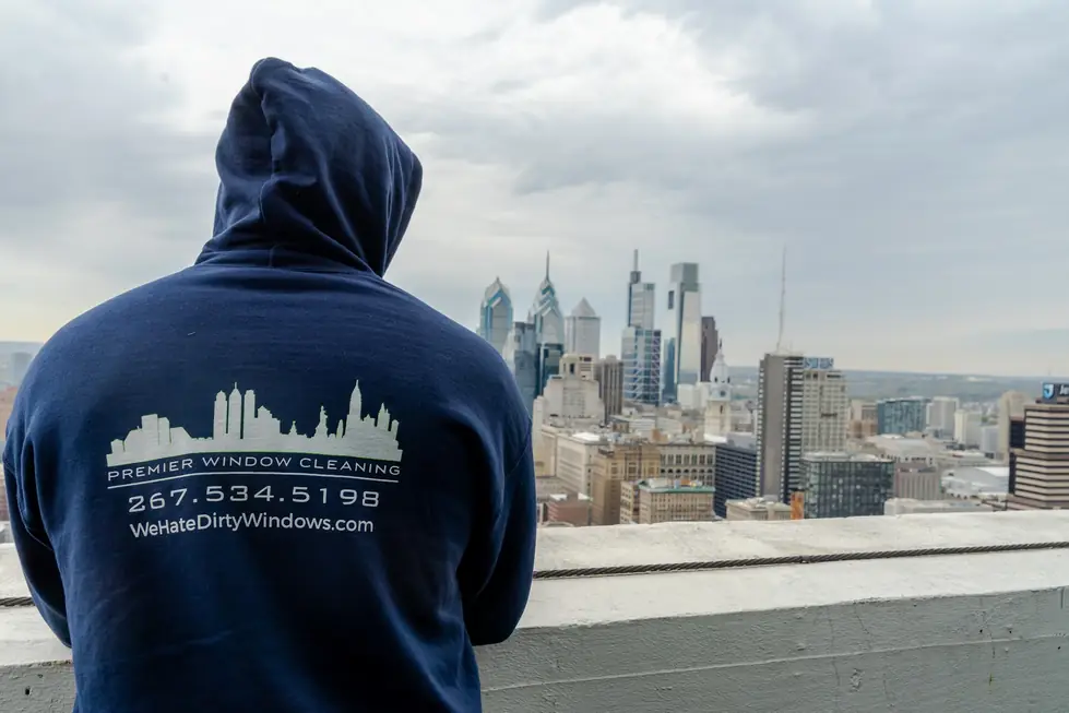 A Premier technician in the company hoodie looks out over the Philadelphia skyline