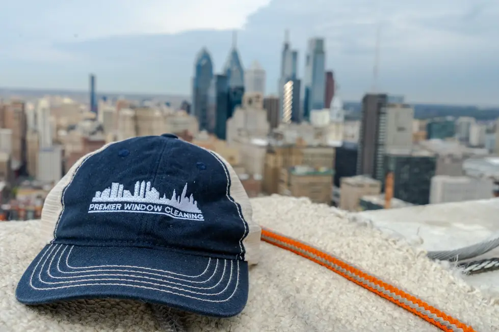 Premier cap and an orange rope line on a rooftop ledge, skyline beyond